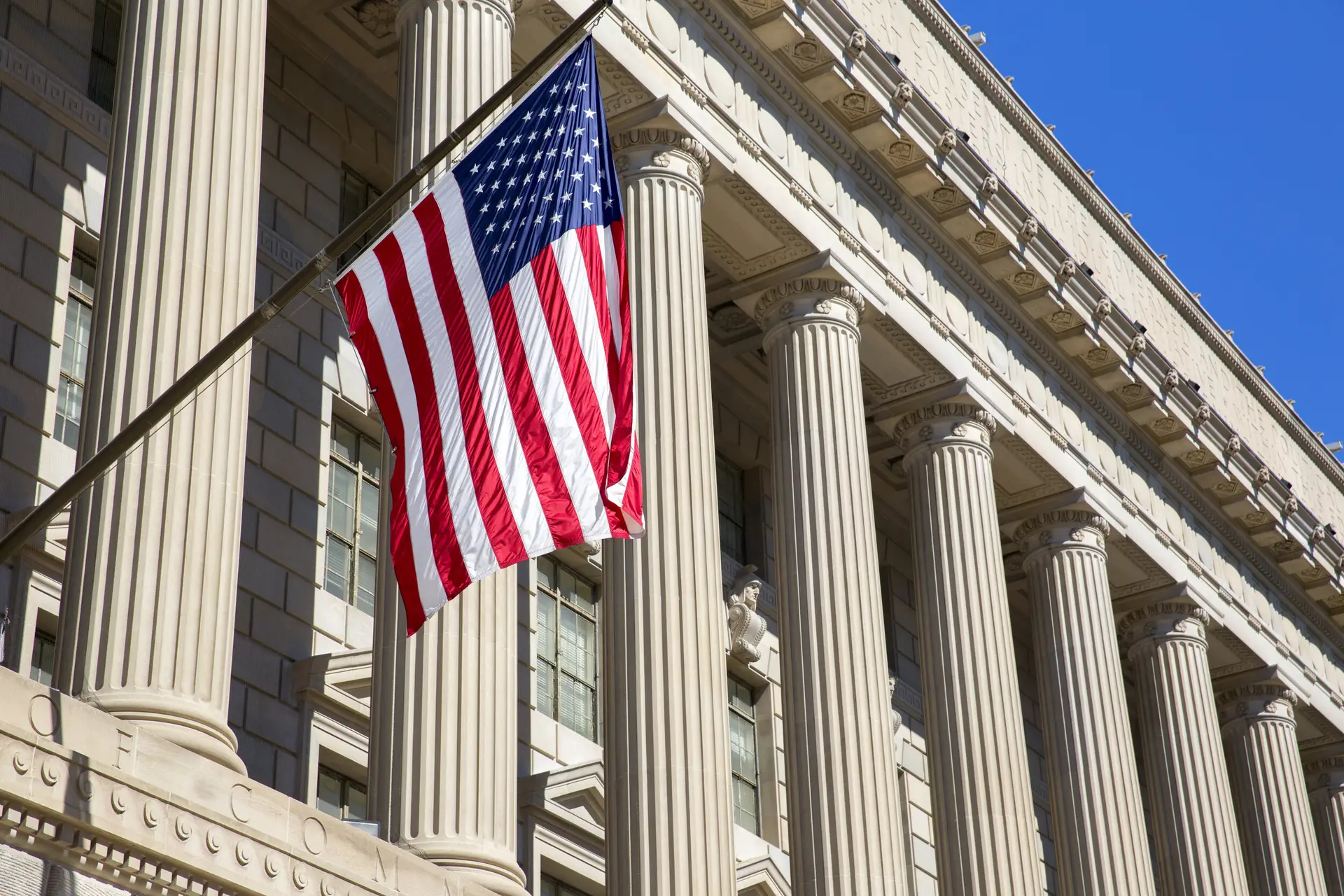 American flag hanging in front of a columned government building